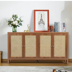 a wooden cabinet with wicker doors on the top and bottom, in front of a white wall