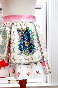 a dress on display in front of a window with an apron hanging from it's waist