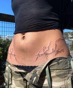 a woman's stomach with tattoos on it