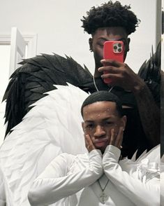 a man taking a selfie with an angel costume