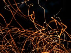 an abstract photograph of orange and yellow lines on a black background in the night time