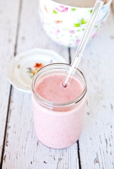 a pink smoothie in a mason jar with a straw