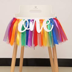 a chair with a colorful tulle skirt and the word love spelled out on it