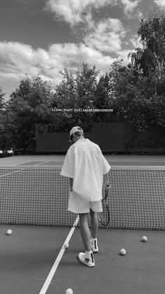 a man standing on a tennis court holding a racquet and ball in his hand