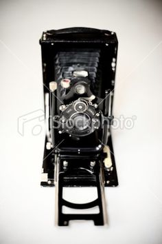 an old camera sitting on top of a wooden stand