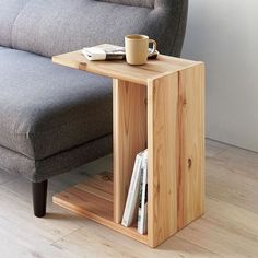 a wooden table with a cup on it next to a couch