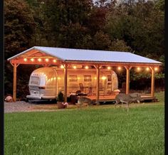 an rv is parked in front of a house with lights on the roof and deer