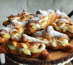 several pastries on a wooden platter with powdered sugar and butter toppings