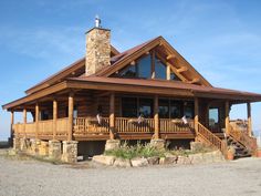 a large log cabin style home with stone and wood accents on the front porch area