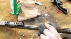 a person is using a hammer to fix a piece of metal on a table with other tools