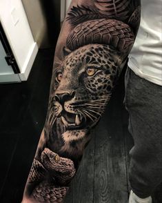 a man's arm with an animal and snake tattoo on the forearm, in black and grey