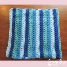 a blue and white crocheted dishcloth on a wooden table