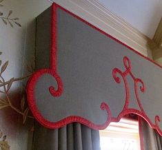 a red and gray window valance hanging from the side of a window