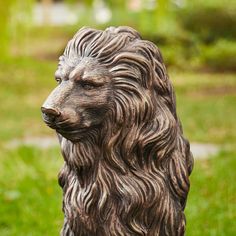 a statue of a lion sitting in the grass