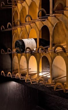 a wine rack with several bottles on it in a room filled with wood and metal