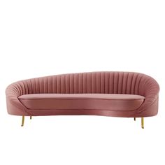 a pink velvet couch with gold legs