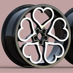 two black wheels with hearts on them, one is painted white and the other is black