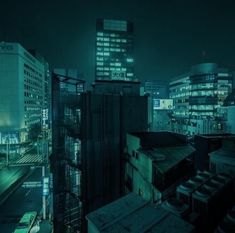 a city at night with tall buildings lit up in the distance and cars parked on the street