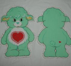 two green teddy bears sitting next to each other on a white tablecloth with red heart