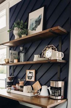 some shelves with coffee cups and other items on them in a room that has blue walls