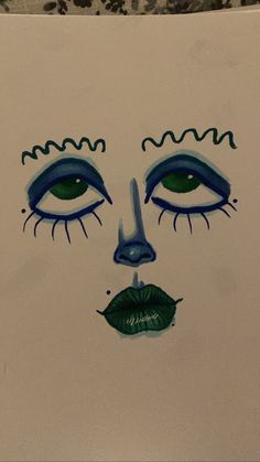 a drawing of a woman's face with blue eyes and green lipstick on it