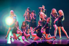 a group of young women standing on top of a stage