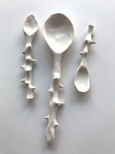 three spoons with spikes on them sitting next to each other