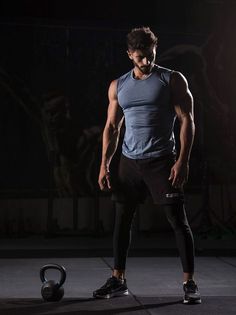 a man standing next to a kettle in the dark with his hands on his hips