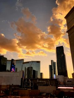 the sun is setting over some buildings and skyscrapers