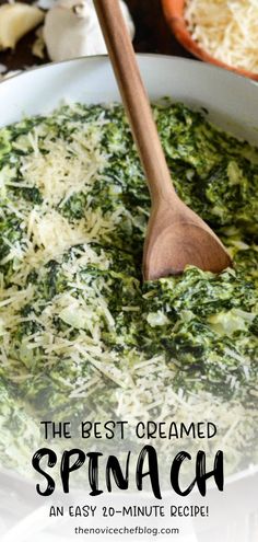 spinach and cheese is being stirred in a pan with a wooden spoon on the side