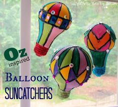 three colorful hot air balloons hanging from a window sill with the words balloon sun catchers