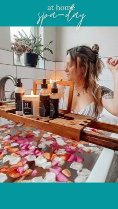 a woman sitting at a table with candles in front of her and flowers on the floor