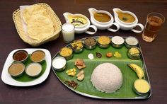 a plate with rice, sauces and other food items on it next to drinks