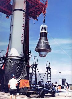 the space shuttle is being lifted into position by two men in white shirts and black shorts