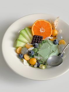 a white bowl filled with assorted fruits and vegetables