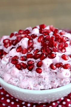 pomegranate in a white bowl on a red and white tablecloth with polka dots