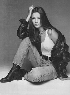 a black and white photo of a woman sitting on the ground