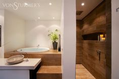 a bathroom with a tub, sink and wooden steps leading up to the bathtub