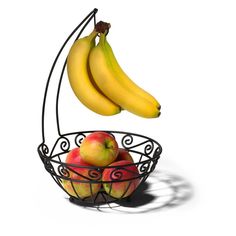 two bananas hanging from a wire basket with apples and pears in it on a white background