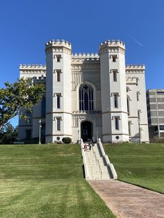 a large white castle with stairs leading up to the front door and side entrance on a sunny day