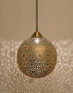 an intricately designed light fixture casts a shadow on the wall in this photo,