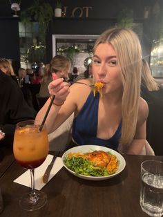 a woman sitting at a table with a plate of food in front of her