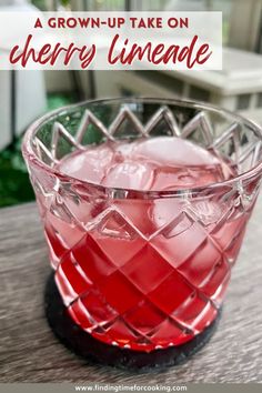 a red drink in a glass on top of a wooden table with text overlay reading a grown - up take on cherry limeade