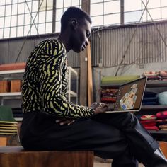 a man sitting on a bench using a laptop computer