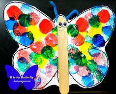 a butterfly made out of colored paper and a wooden stick