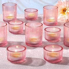 pink glass candles are lined up on a table