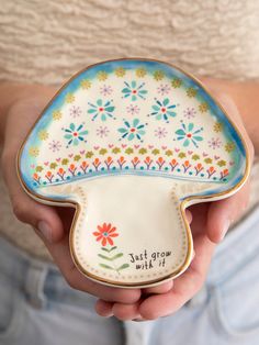 a person is holding a decorative dish in their hands with the words, just grow wild on it