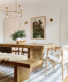 a dining room table with two chairs and a bench in front of it on a rug