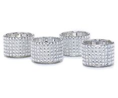 four silver candlesticks with white diamonds on them