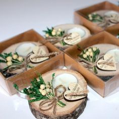 four small boxes with candles in them are sitting on a table together, tied with twine and flowers